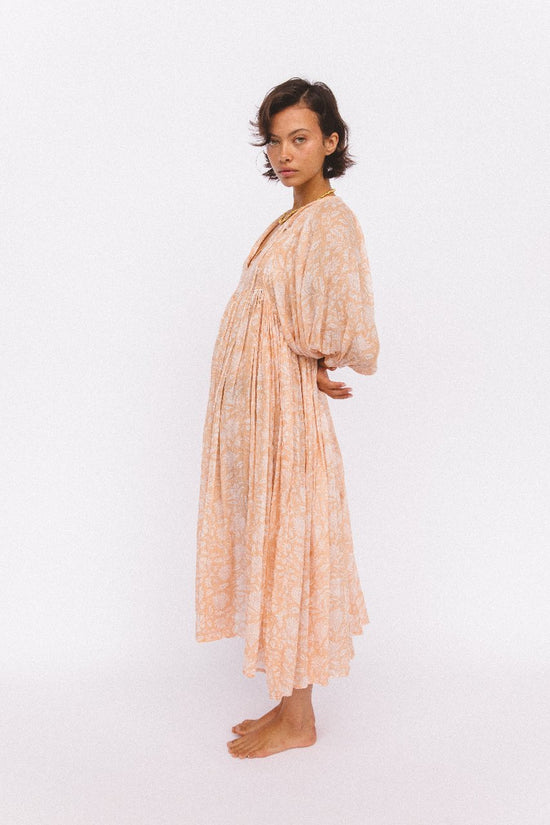 Daughters of India Kyra Midi Dress in Apricot Blush — studio side profile, billowed sleeves and gathered waist, hand screen print cotton