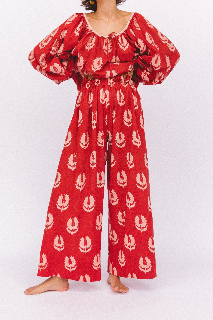 Ria Pants Ruby Red — studio full length front view, model wearing ruby red hand block print cotton wide-leg pants with botanical leaf motif, barefoot styling, artisan Jaipur India | Daughters of India