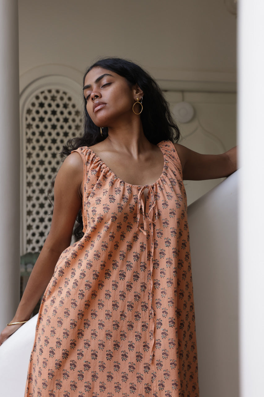 Sundress Midi Peach — model twirling full skirt, movement shot showing A-line skirt flare, peach floral block print cotton midi dress, effortless summer style, artisan Jaipur India | Daughters of India