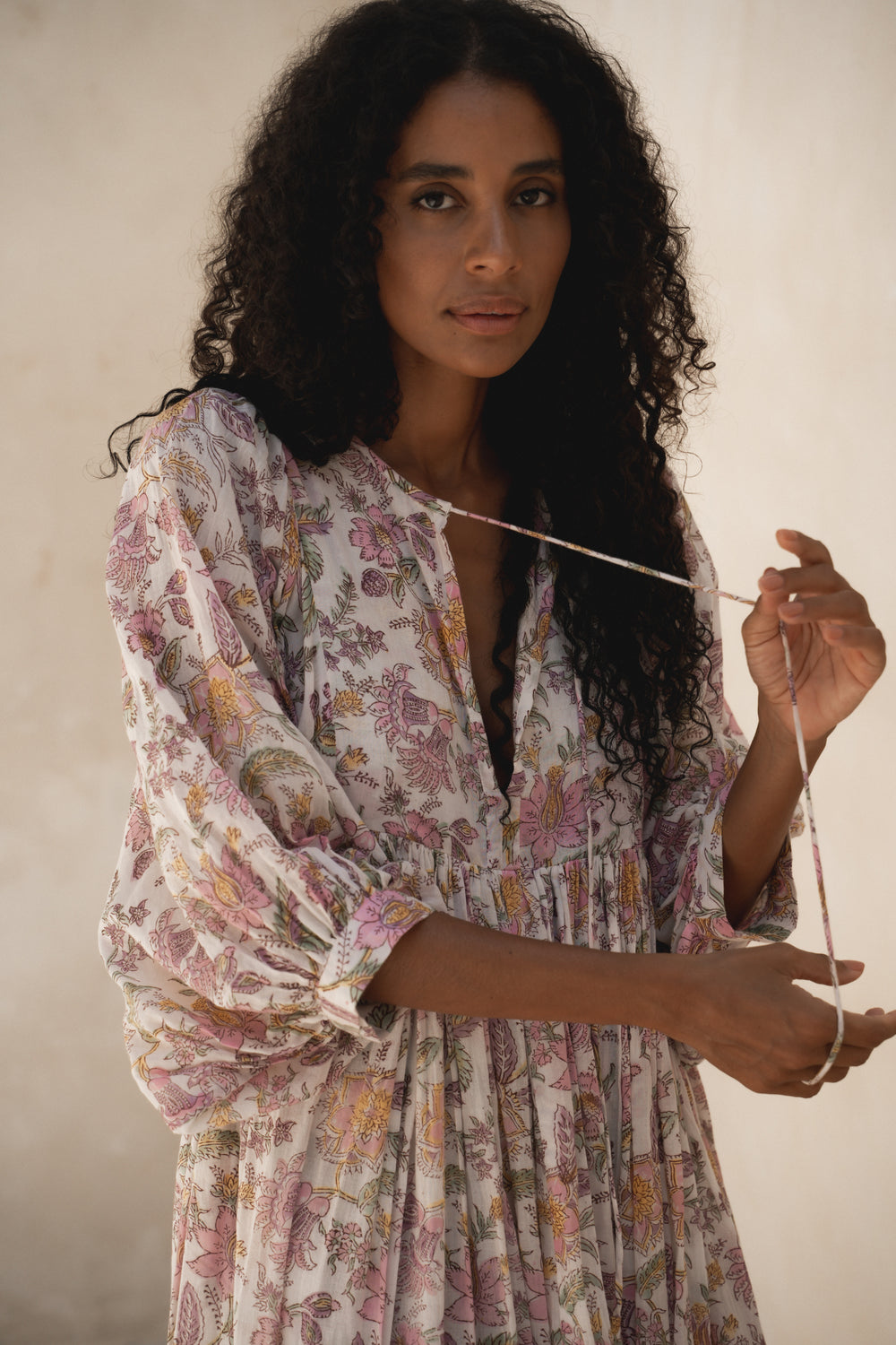 Daughters of India Kyra Maxi Dress in Fuchsia Bloom — close-up holding neckline tie, V-neckline and floral print detail